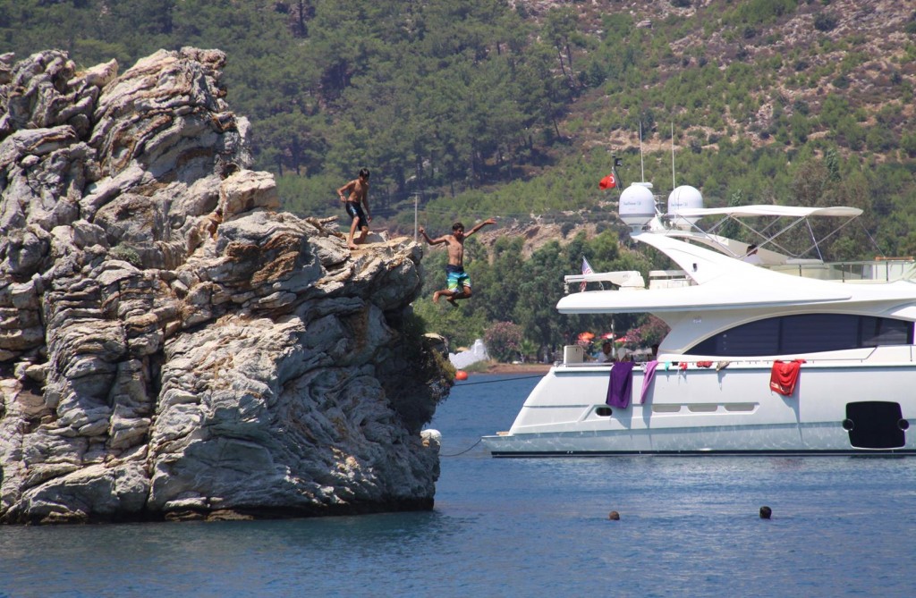 Young Local Boys have Fun Jumping from the Cliffs on the Island