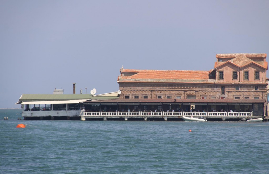 Built Out Over the Water is a Large Long Building with Many Restaurants that Seems to be Full at Lunch and Dinner Times 