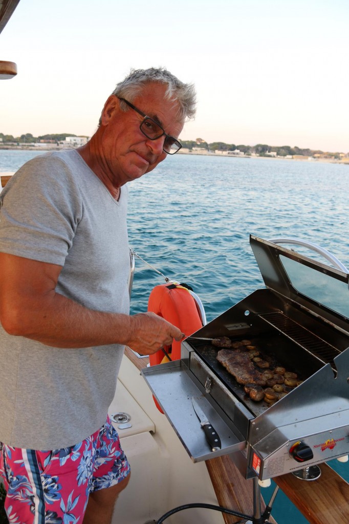 Ric with his pride and joy -our barbecue aboard, all the way from Australia